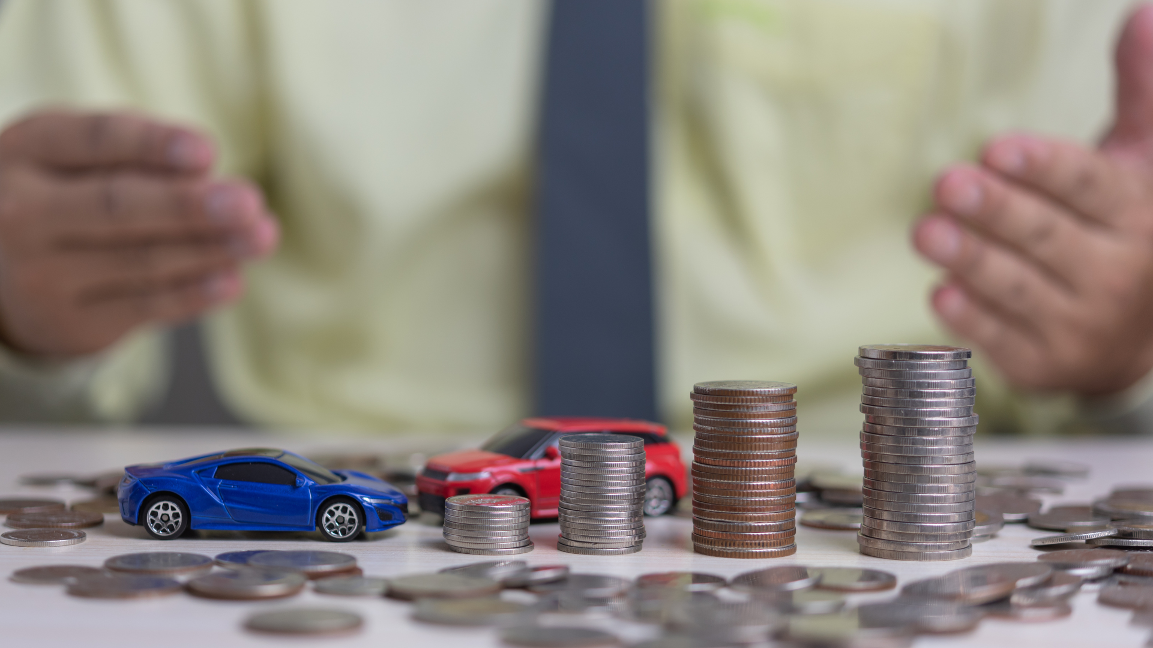 vehicle finance shown with 2 toy vehicles with coins